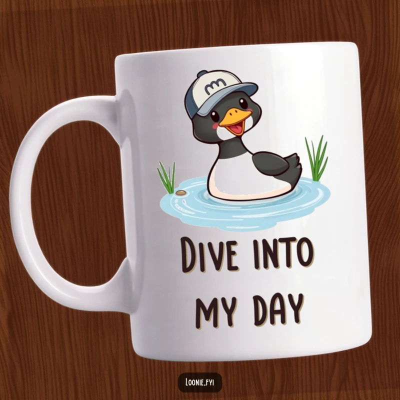 Funny mug with a playful loon wearing a baseball cap, captured mid-dive into a small lake, showcasing a humorous wildlife scene.