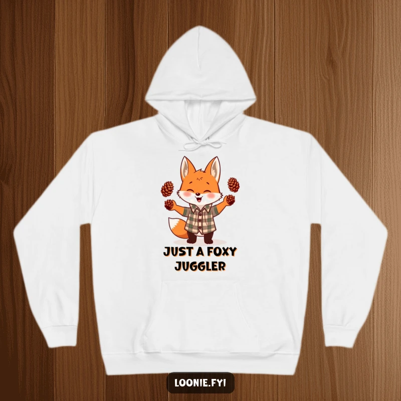 Funny hoodie featuring a happy, giggling fox in a plaid shirt, impressively juggling three pinecones, perfect for cozy humor.